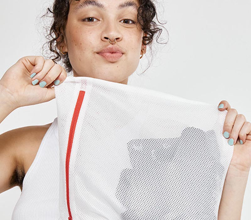 Girl putting Scarlet Period underwear in the washing machine