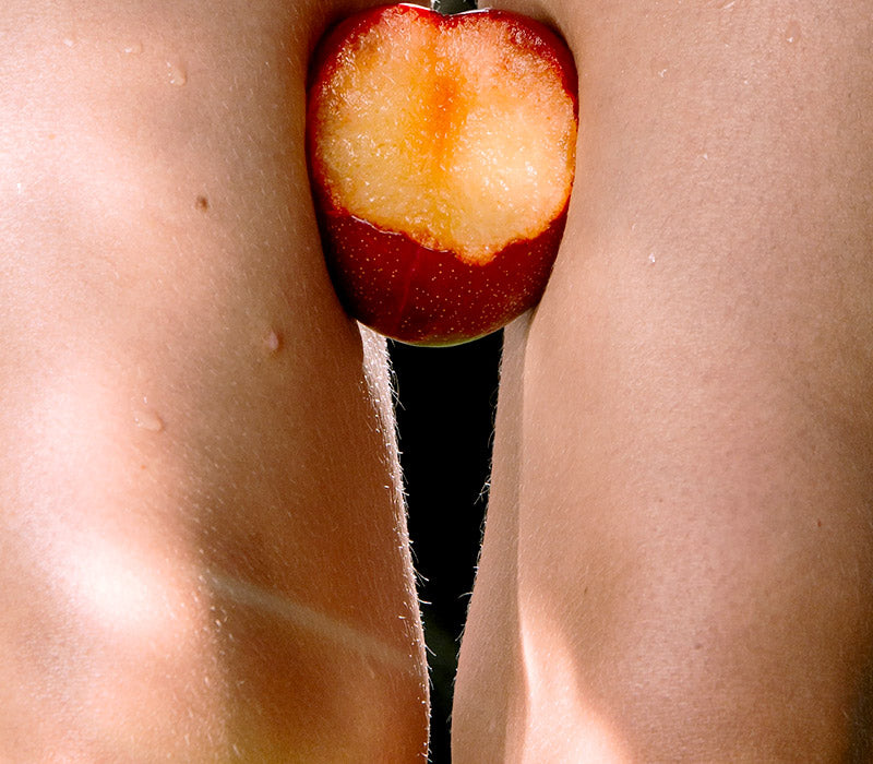 SCARLE BLOG IMAGE | Girl with fruit with bite out of it between legs 