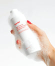 Hand with bubbles holding Scarlet Daily All-Over Cleanser